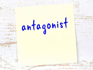 Düşmanı hatırlatma kavramı. Tahta duvarda üzerinde yazı olan sarı yapışkan kağıt.