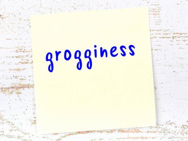 Ahşap duvardaki sarı yapışkan notta el yazısıyla yazılmış içki sersemliği var.