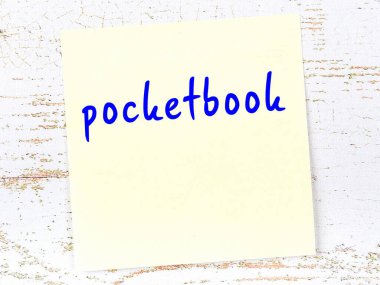 Ahşap duvarda el yazısıyla yazılmış el yazısı cüzdanı olan sarı yapışkan bir not.