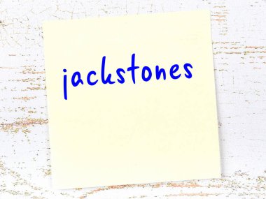 Jackstone 'ları hatırlatma kavramı. Tahta duvarda üzerinde yazı olan sarı yapışkan kağıt.