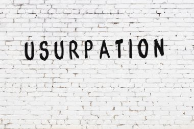 Siyah boyayla el yazısıyla el yazısıyla gasp edilmiş beyaz tuğla duvar.