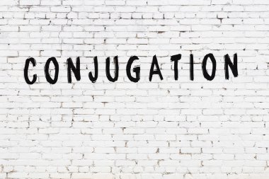 Siyah boyayla el yazısıyla yazılmış beyaz tuğla duvar.