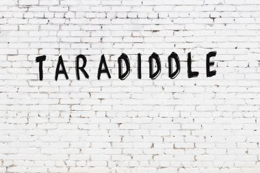 Yazı, beyaz tuğla duvara siyah boya ile yazılmış..