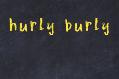 Tebeşir el yazısıyla yazılmış yazı alelacele siyah masaya yazılmış.