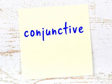 Ahşap duvarda el yazısıyla yazılmış sarı yapışkan bir not var.