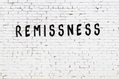 Üzerinde siyah boya bulunan beyaz tuğlalı bir duvar.