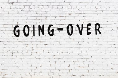 Üzerinde siyah boya olan beyaz tuğla bir duvar.