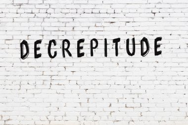 Üzerinde yazı olan beyaz tuğla duvar, el yazısıyla siyah boya ile çizilmiş.