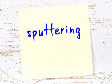 Tahta duvardaki sarı yapışkan notta el yazısıyla yazılmış tükürük var.