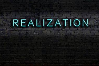 Üzerinde tuğla duvara karşı yazılar olan neon tabela. Gece görünümü