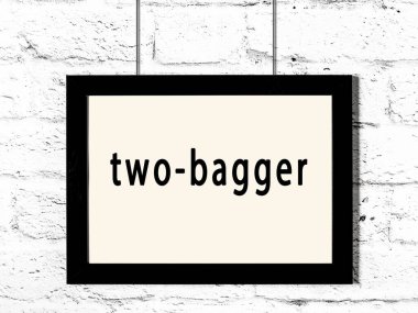 Siyah ahşap çerçeve, beyaz duvarda iki torba asılı. 