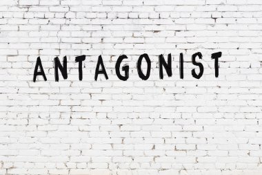 Üzerinde siyah boya bulunan beyaz tuğlalı bir duvar.