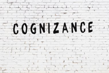 Beyaz tuğla duvarda siyah boyayla yazılmış bir yazı..