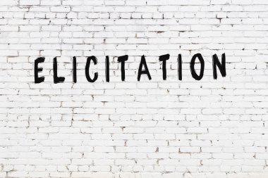 Beyaz tuğla duvara siyah boya ile yazılmış bir yazı..