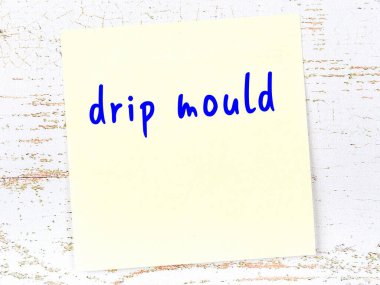 Tahta duvardaki sarı yapışkan notta el yazısıyla yazılmış damlalar var.