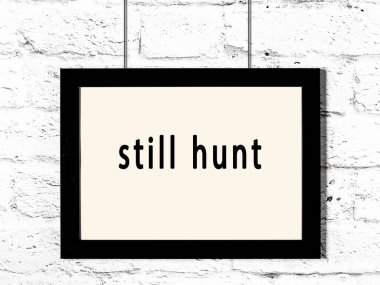 Üzerinde yazı olan siyah ahşap çerçeve hala beyaz tuğla duvarda asılı avlanıyor. 