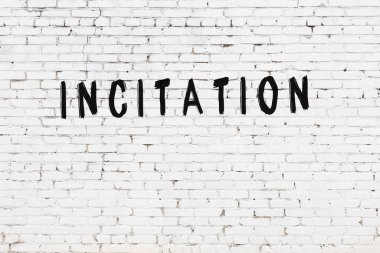 Üzerinde siyah boya bulunan beyaz tuğla bir duvar.