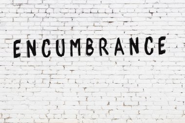 Yazı, beyaz tuğla duvara siyah boya ile yazılmış..