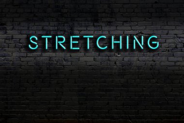 Duvara doğru uzanan bir neon levhası var. Gece görünümü