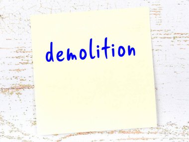 Yıkım hakkında hatırlatma kavramı. Tahta duvarda üzerinde yazı olan sarı yapışkan kağıt.