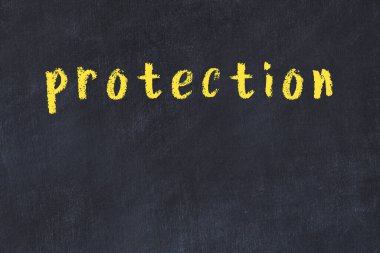 Tebeşir el yazısıyla yazılmış yazı koruması siyah masada.