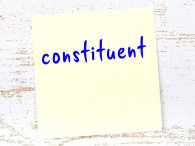 Tahta duvarda el yazısıyla yazılmış sarı yapışkan bir not var.