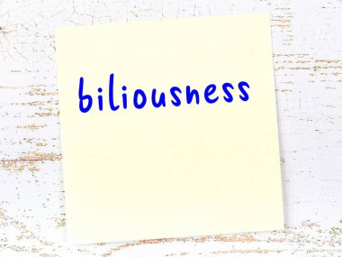 Tahta duvarda el yazısıyla yazılmış sarı yapışkan bir not.