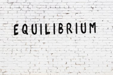 Siyah boyayla el yazısıyla yazılmış beyaz tuğlalı bir duvar.