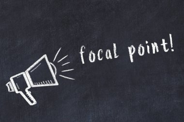 Hoparlörün tebeşir çizimi ve siyah masanın üzerine el yazısıyla yazılmış yazı odak noktası