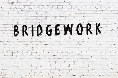 Üzerinde siyah boya bulunan beyaz tuğlalı bir duvar.