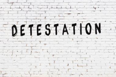 Üzerinde siyah boya bulunan beyaz tuğlalı bir duvar.