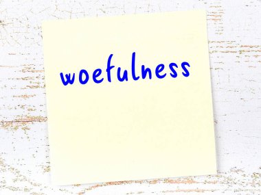 Tahta duvarda el yazısıyla yazılmış keder dolu sarı yapışkan bir not.