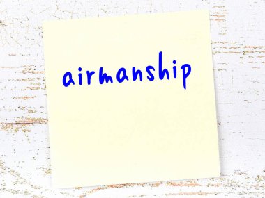 Tahta duvardaki sarı yapışkan notta el yazısıyla yazılmış havacılık.