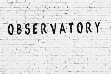 Üzerinde siyah boya bulunan beyaz tuğlalı bir duvar.