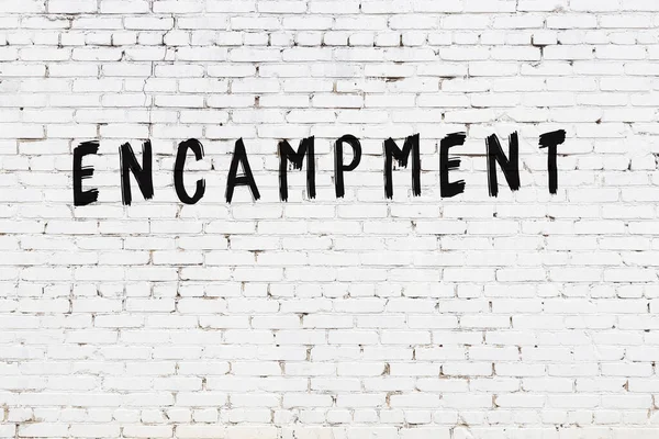 Üzerinde siyah boya bulunan beyaz tuğladan bir duvar.