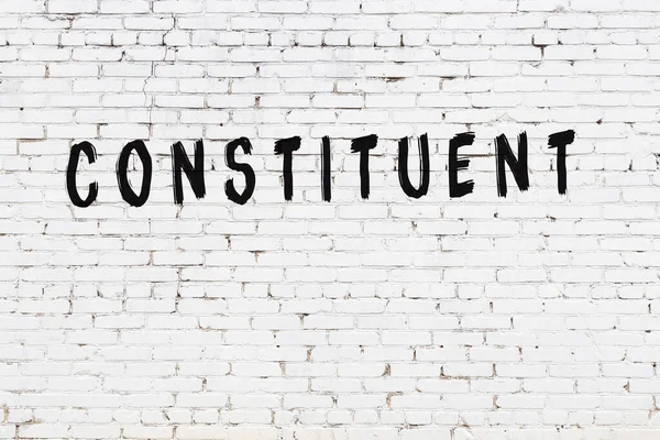 Beyaz tuğladan duvar, siyah boyayla el yazısıyla yazılmış.