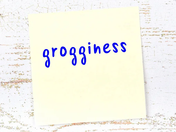 Ahşap duvardaki sarı yapışkan notta el yazısıyla yazılmış içki sersemliği var.