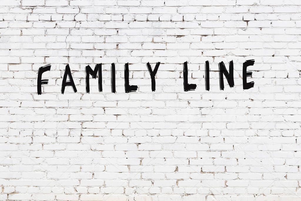 Inscription family line written with black paint on white brick wall.