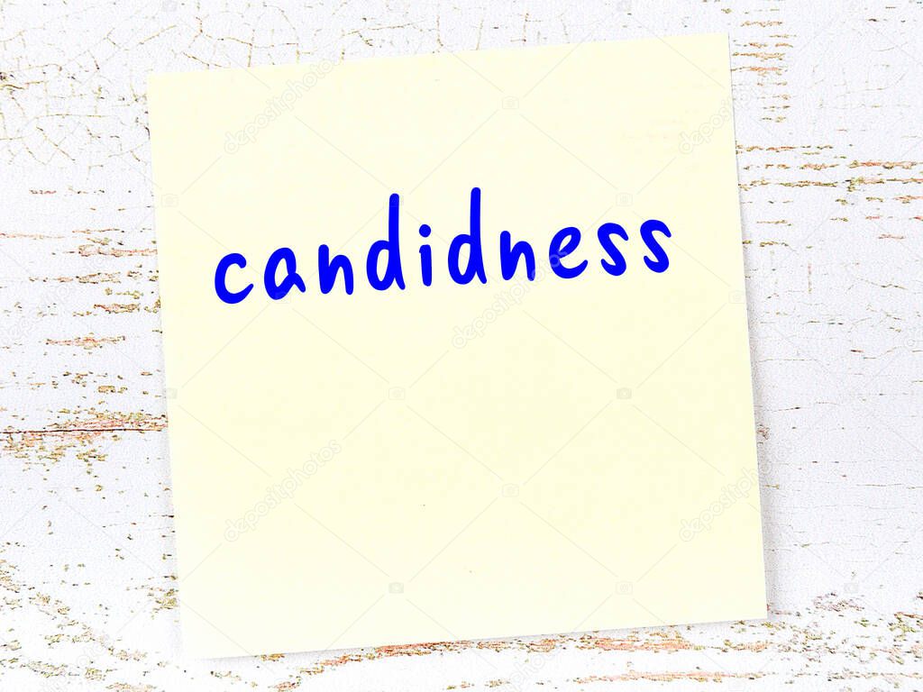 Concept of reminder about candidness. Yellow sticky sheet of paper on wooden wall with inscription