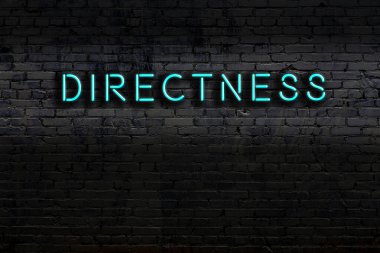 Tuğla duvara karşı doğrudan yazı yazan neon tabela. Gece görünümü