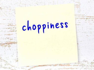 Tahta duvardaki sarı yapışkan nota, el yazısıyla yazılmış keskinlik.