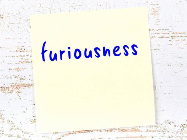 Tahta duvardaki sarı yapışkan notta el yazısıyla yazılmış öfke yazısı var.