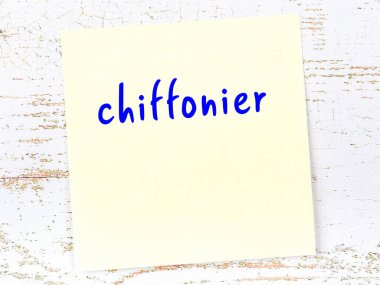 Şifoniyeri hatırlatma kavramı. Tahta duvarda üzerinde yazı olan sarı yapışkan kağıt.