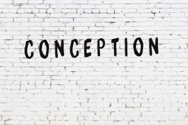 Üzerinde siyah boya olan beyaz tuğla bir duvar.