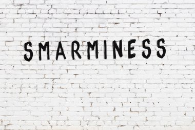 Beyaz tuğla duvara siyah boya ile yazılmış bir yazı..