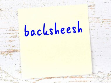 Geri tepmeyle ilgili hatırlatma kavramı. Tahta duvarda üzerinde yazı olan sarı yapışkan kağıt.