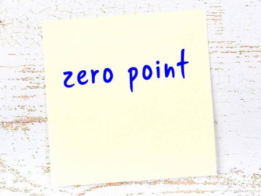 Tahta duvarda elle yazılmış sıfır noktası olan sarı yapışkan bir not.