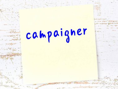 Tahta duvarda sarı yapışkan bir not ve el yazısı kampanyası.