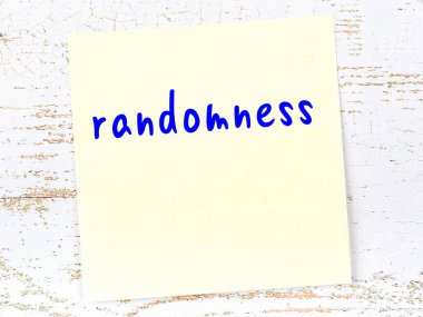 Rastgeleliği hatırlatma kavramı. Tahta duvarda üzerinde yazı olan sarı yapışkan kağıt.