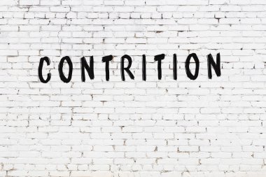 Yazı, beyaz tuğla duvara siyah boya ile yazılmış..